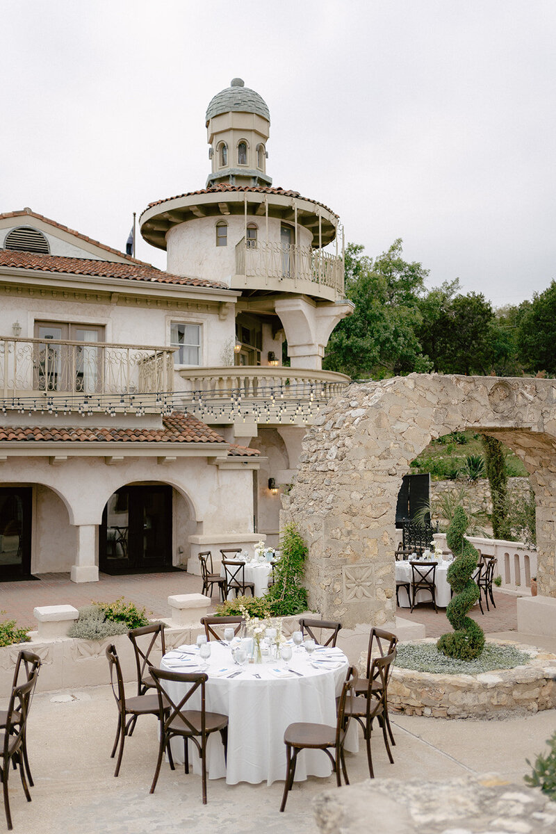 Villa Antonia outdoor wedding reception with round tables, white linens, and European-inspired architecture, planned by Eventive Designs in Austin, Texas.