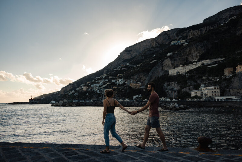 walking along the coast line in Amalfi in Italy while holding hands