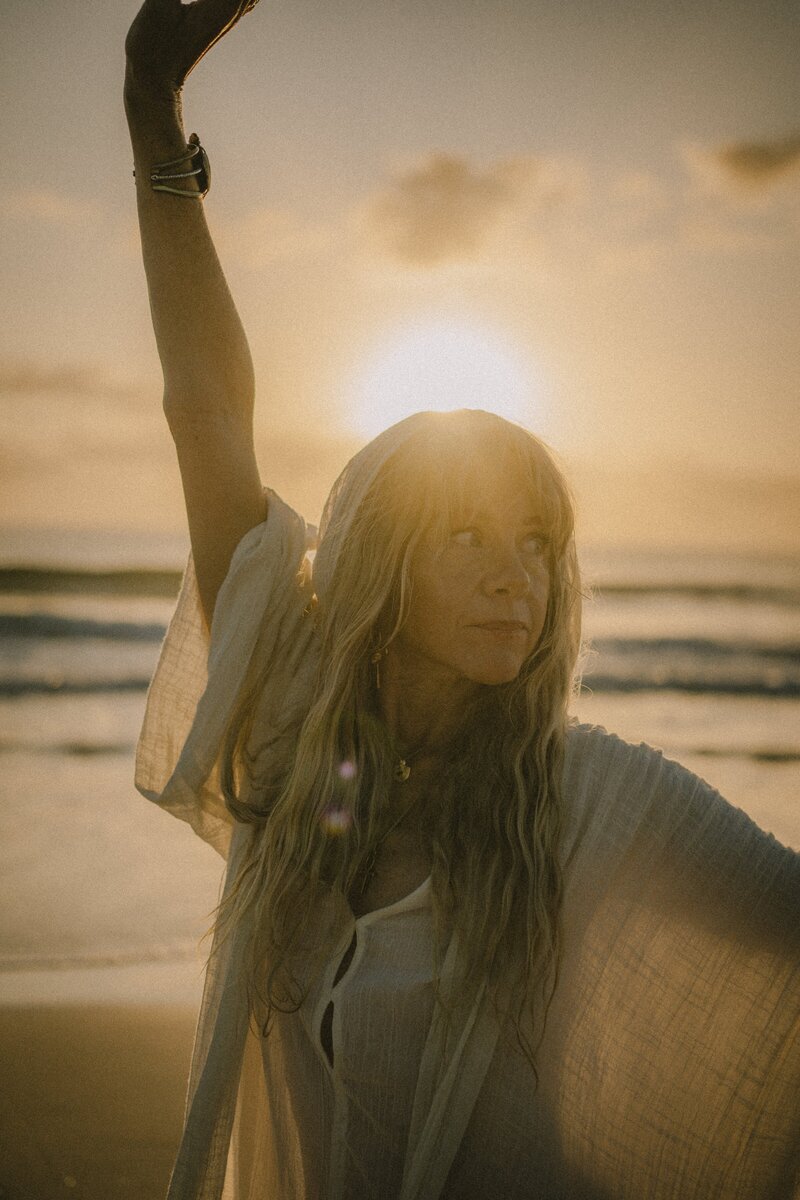 HarJiwan in a yoga artistic pose at sunset on the beach