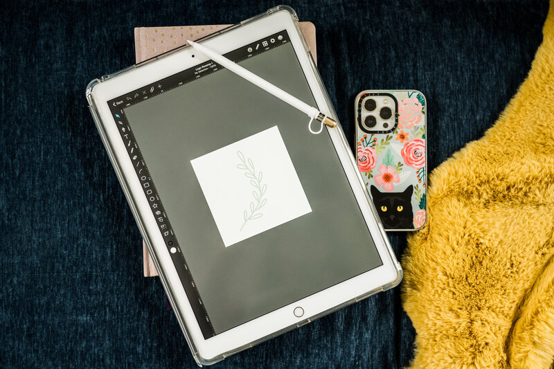 Melonie designing on a tablet, emphasizing the importance of gathering website assets and materials for a successful project with Grassroots Creative Company.