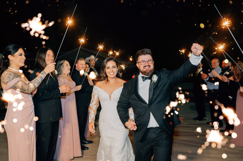 Bride and Groom walk through sparklers at their wedding. Photo by Anna Brace,  one of iowa wedding photographers.