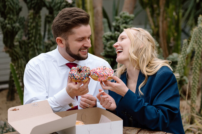 Bride and groom celebrating their elopement with sprinkle donuts.