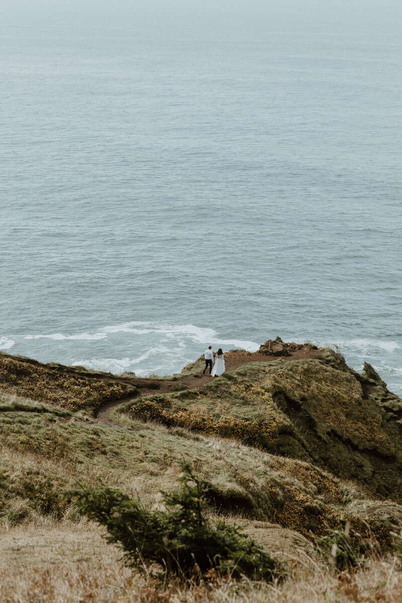 Adventurous couple hiking to a mountain overlook for their PNW elopement