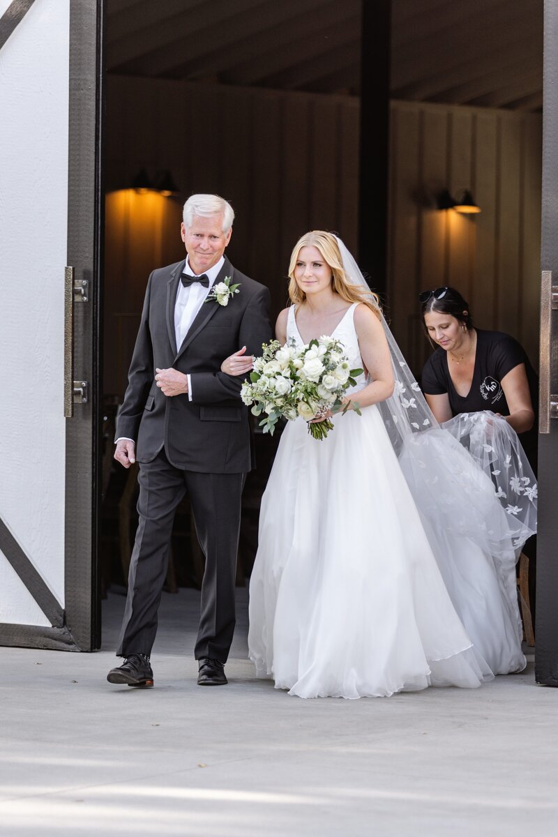 bride being walked down the aisle by her father