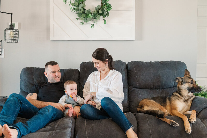 Family sitting on the couch with their kids and dog during a relaxed at-home photo session in York, PA.