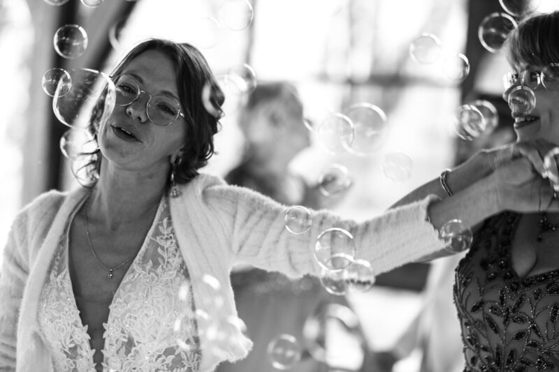 Bride surrounded by bubbles at Pine Junction wedding reception