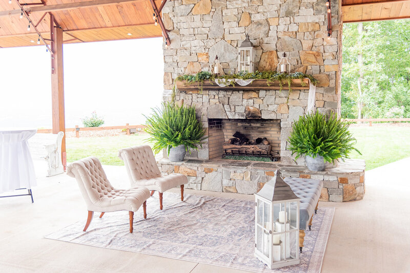 An outdoor setting with chairs and a fireplace.