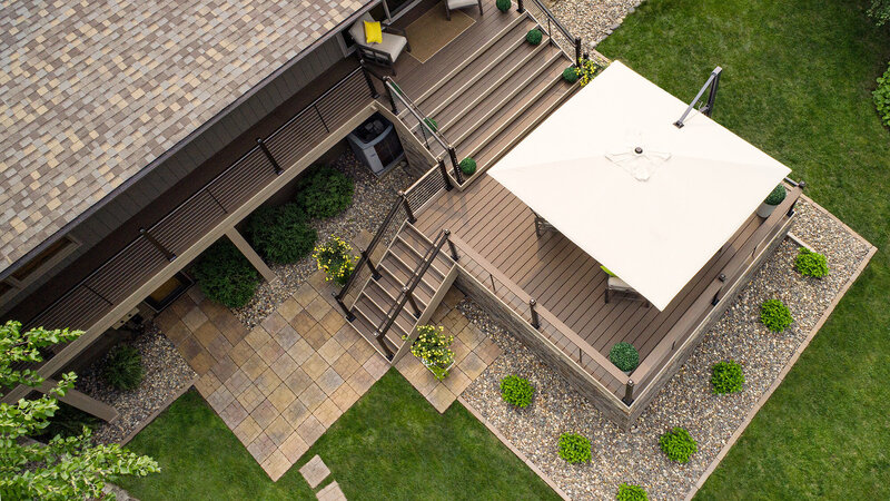 Aerial view of composite deck with a wide staircase leading from the house and a smaller staircase leading down to ground level. 