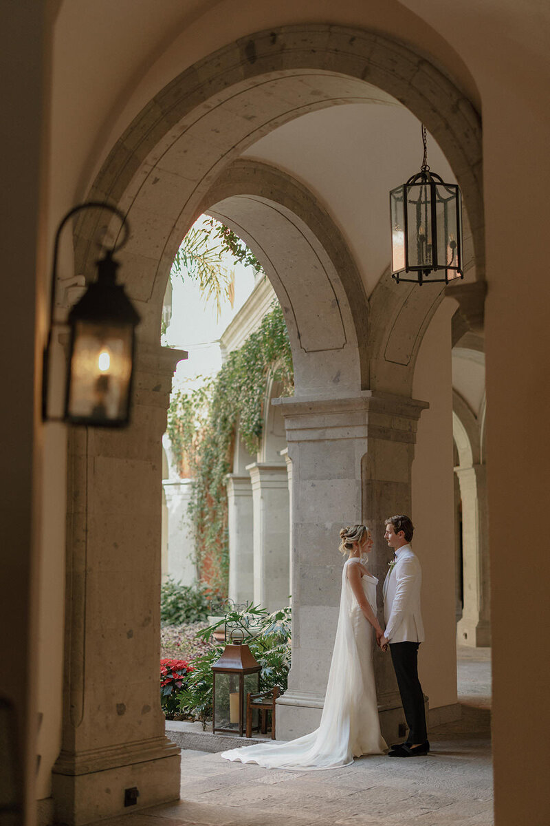 Bride and groom stare lovingly at each other in front of a beautiful bar setup at a private estate wedding  in Ojai California