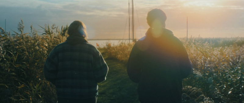 A modern couple walking through the city at dusk, framed with cinematic contrast.