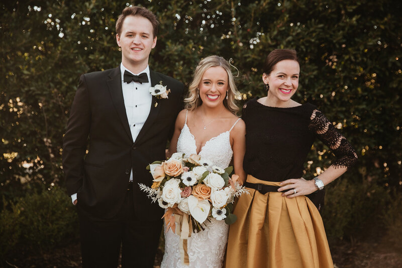 Meg posing with a bride and groom on their wedding day