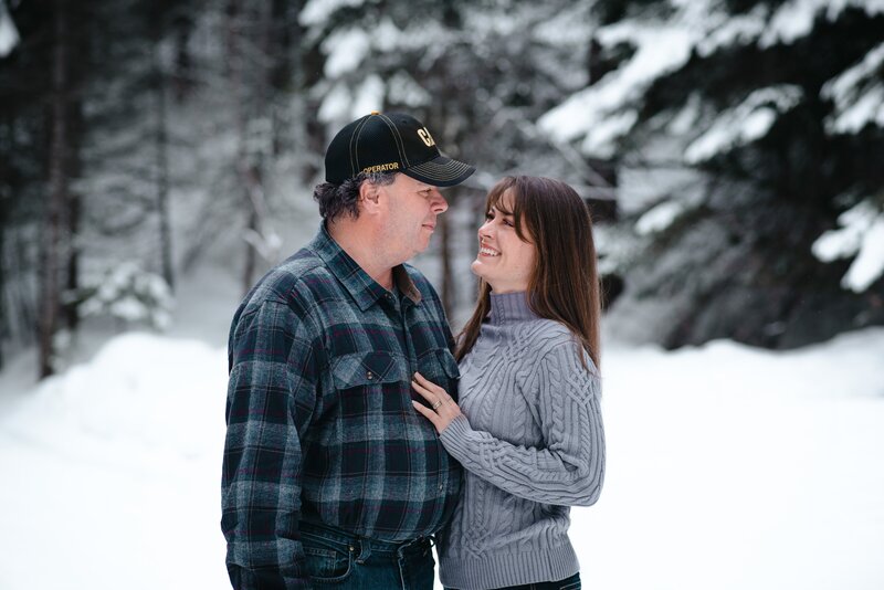 Couple Smiling at one another during a winter family photoshoot in Halfway Oregon