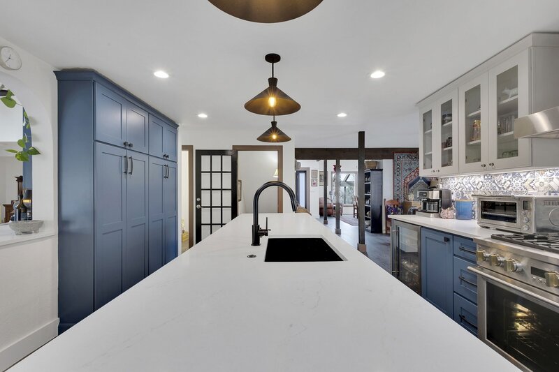 a beautiful kitchen with blue cabinets and wooden accents