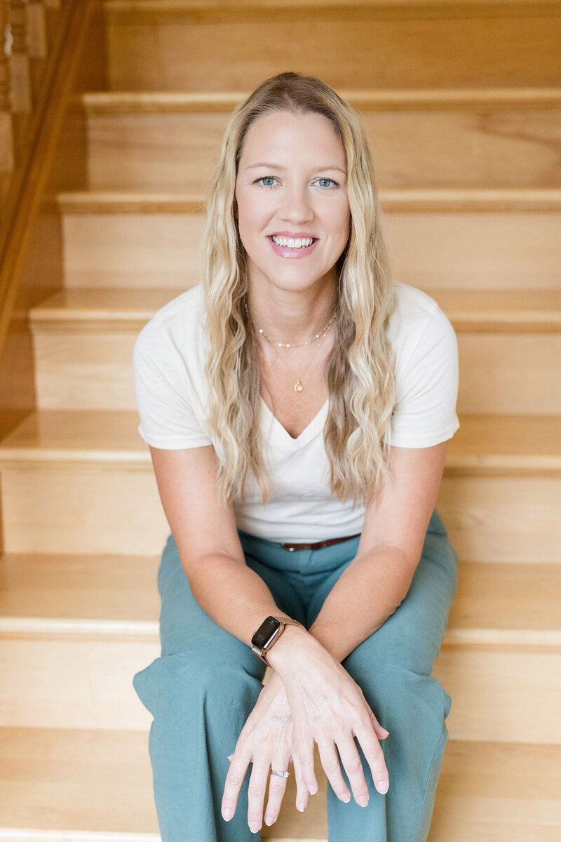 Parent coach Amy Fink sitting on a stair case