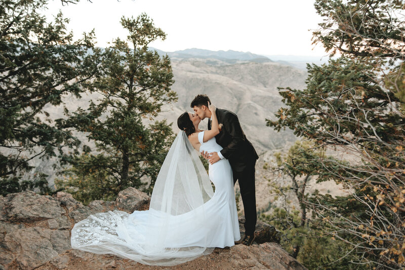 bride and groom standing on a mountain