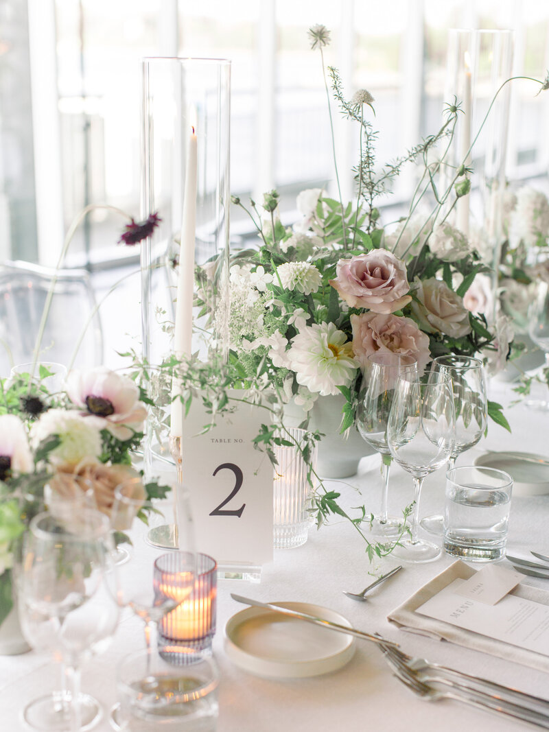 A lush garden centrepiece with pale roses at a Montreal Science Centre wedding reception.