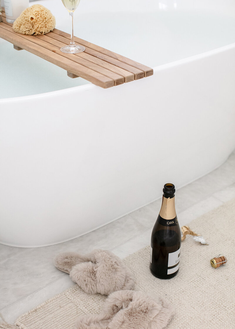 Bathroom photo for a Realtor with a bathtub, slippers, and champagne.