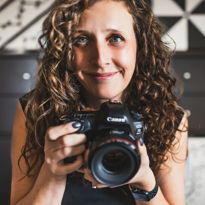 A photo of photographer Heidi Iliff who specializes in family photography with senior portraits in Pittsburgh Pennsylvania holding her camera.