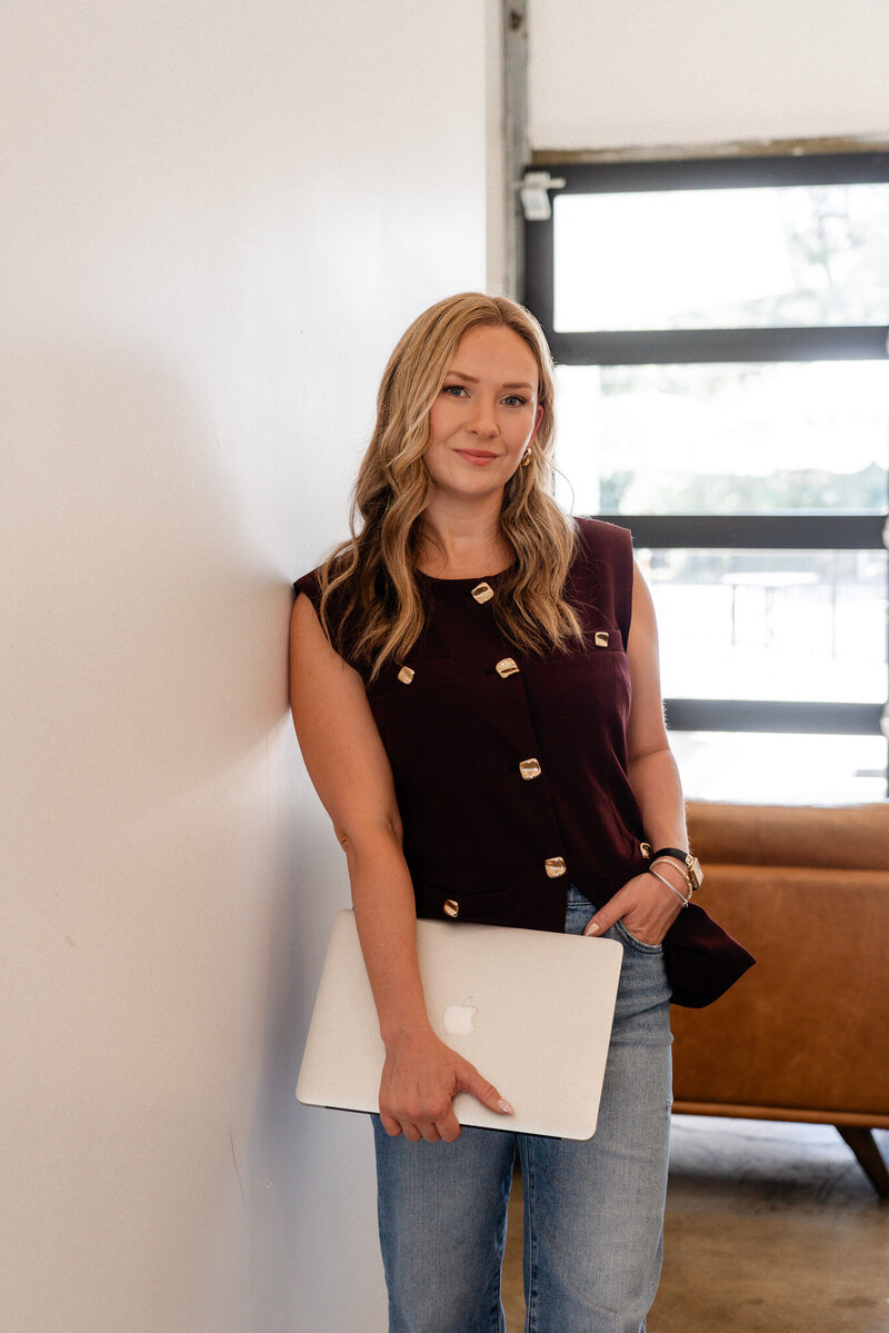 Woman holding laptop, representing Fresh Page Marketing’s Shopify management, Faire wholesale support, copywriting, and web design services for small businesses.