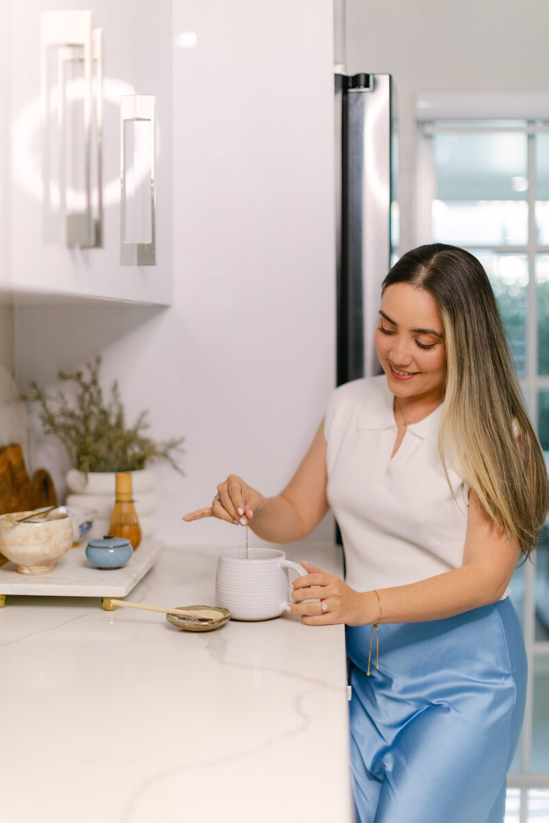 Merlyn Asencio making a cup of tea, embodying a peaceful and nurturing environment that reflects her compassionate trauma therapy practice in Miami.