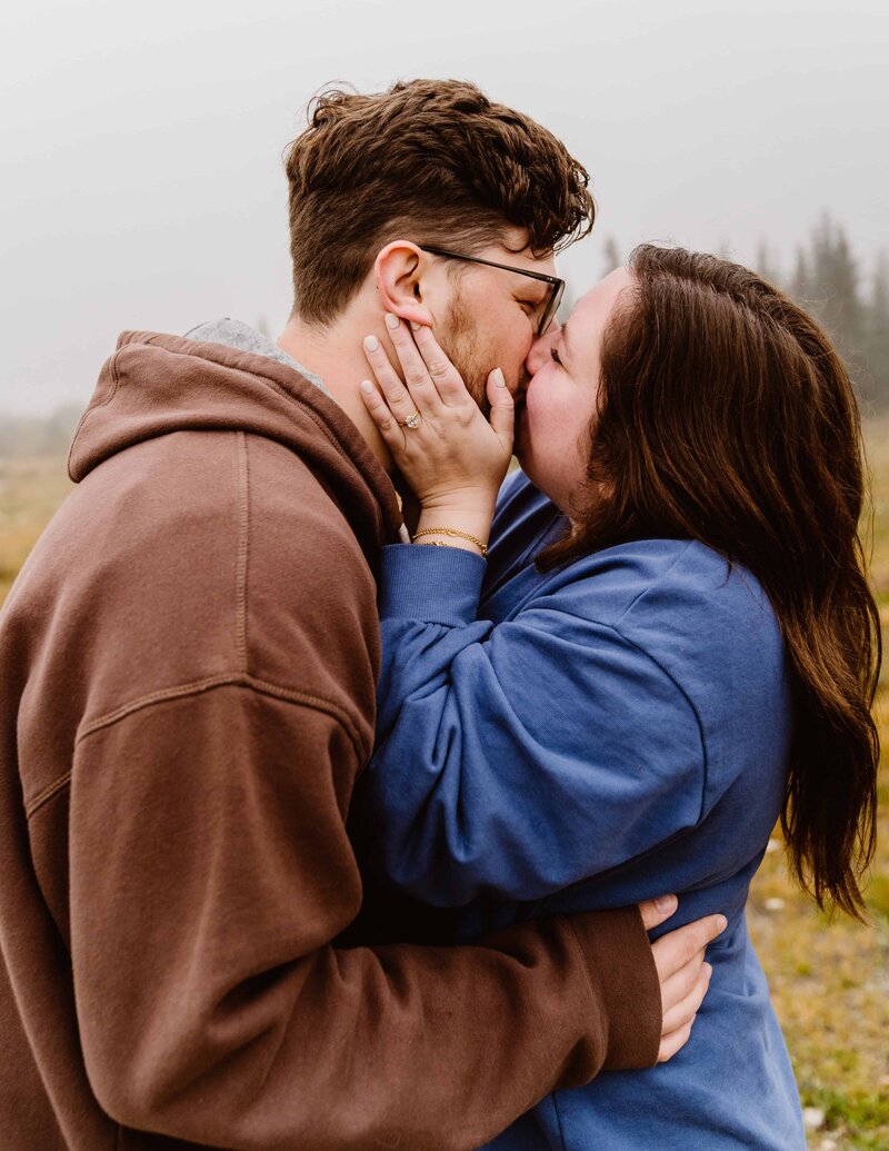Couple kissing right after the boyfriend proposed to his girlfriend and she said yes with Fort Collins, Colorado engagement and couples photography packages.