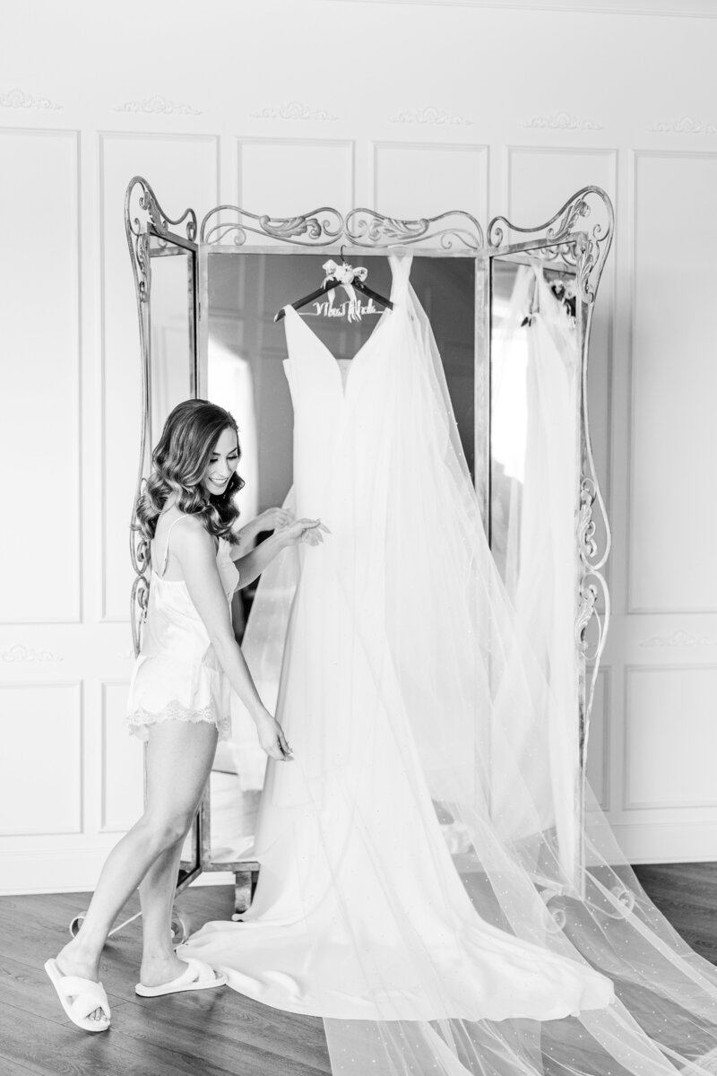 a woman preparing to put on her wedding dress