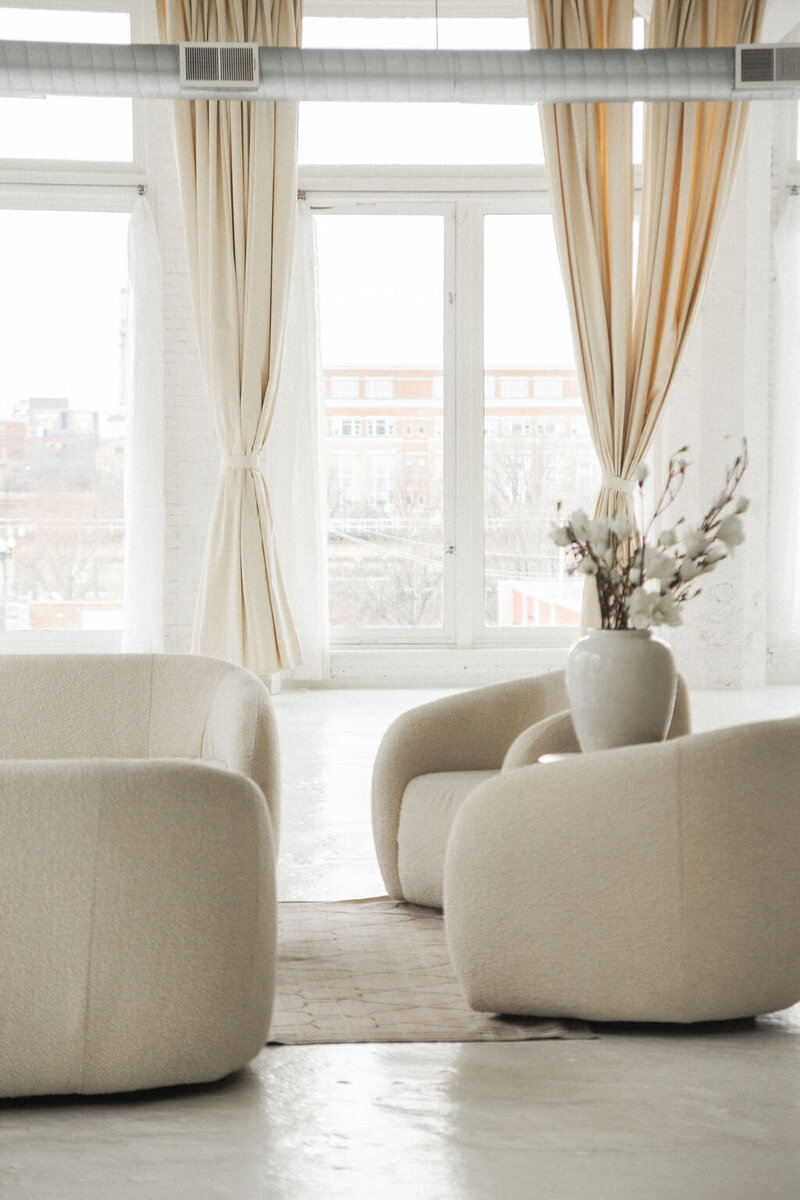 A serene office space with plush chairs and natural light from floor-to-ceiling windows