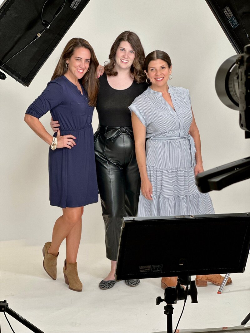 three woman pose for photo in photography studio