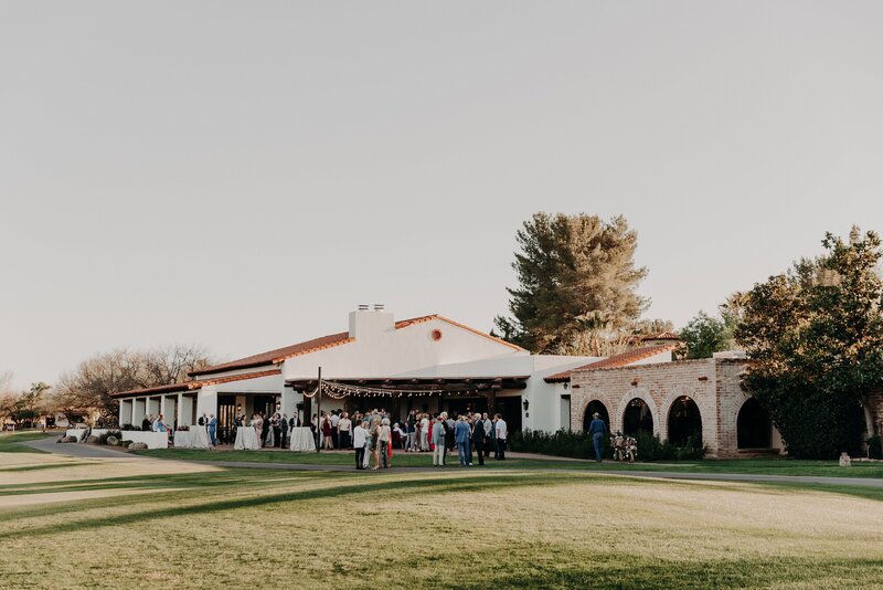 Wedding guests enjoy cocktail hour on lawn