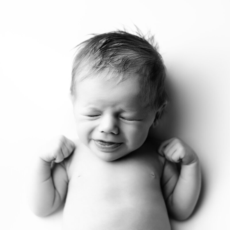 Natural joy, gently captured. A soft smile and sweet stretch preserved in black and white.
