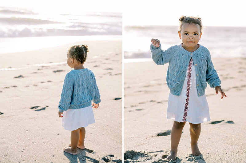 A little girl in a blue sweater looking out at the ocean during a children's photography session in Los Angeles