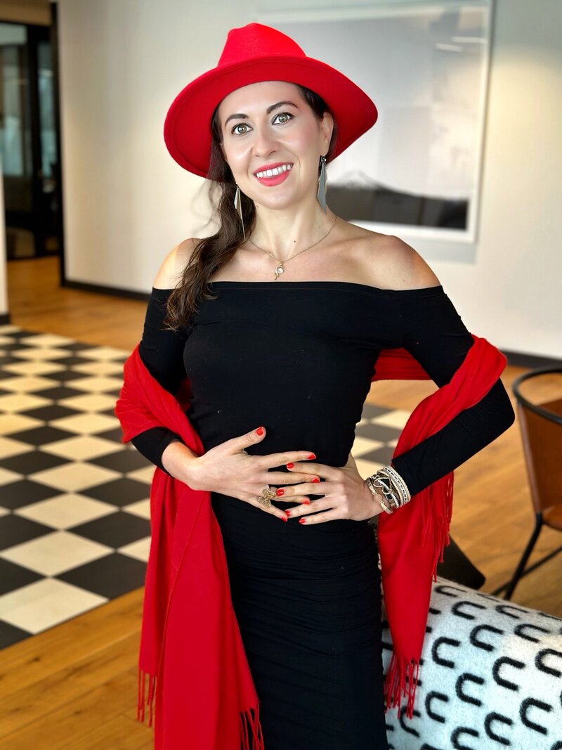 Ana-Maria Georgieva wearing a black dress and red hat and shawl