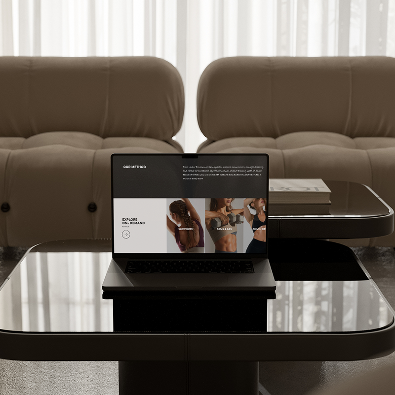 Desktop computer on a table with a couch in a background