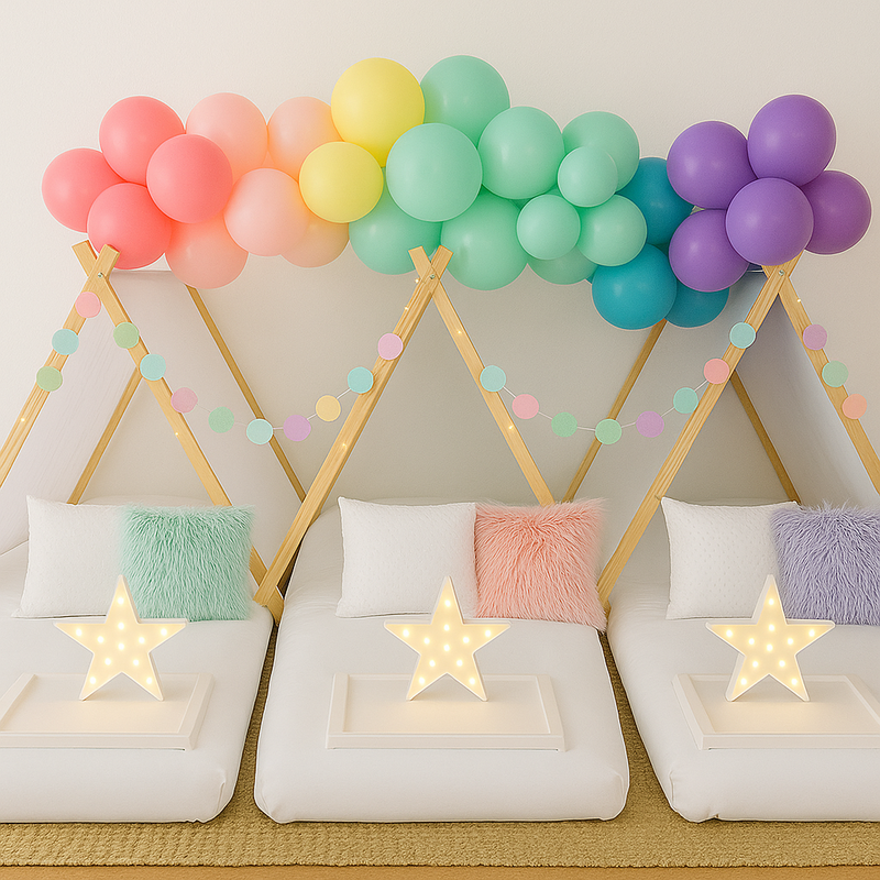white luxury sleepover beds with balloon garland in pink yellow green and purple