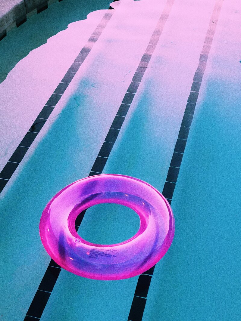 a pink inflatable pool tube in the shallow steps end of a pool for the contact form of socialfizz