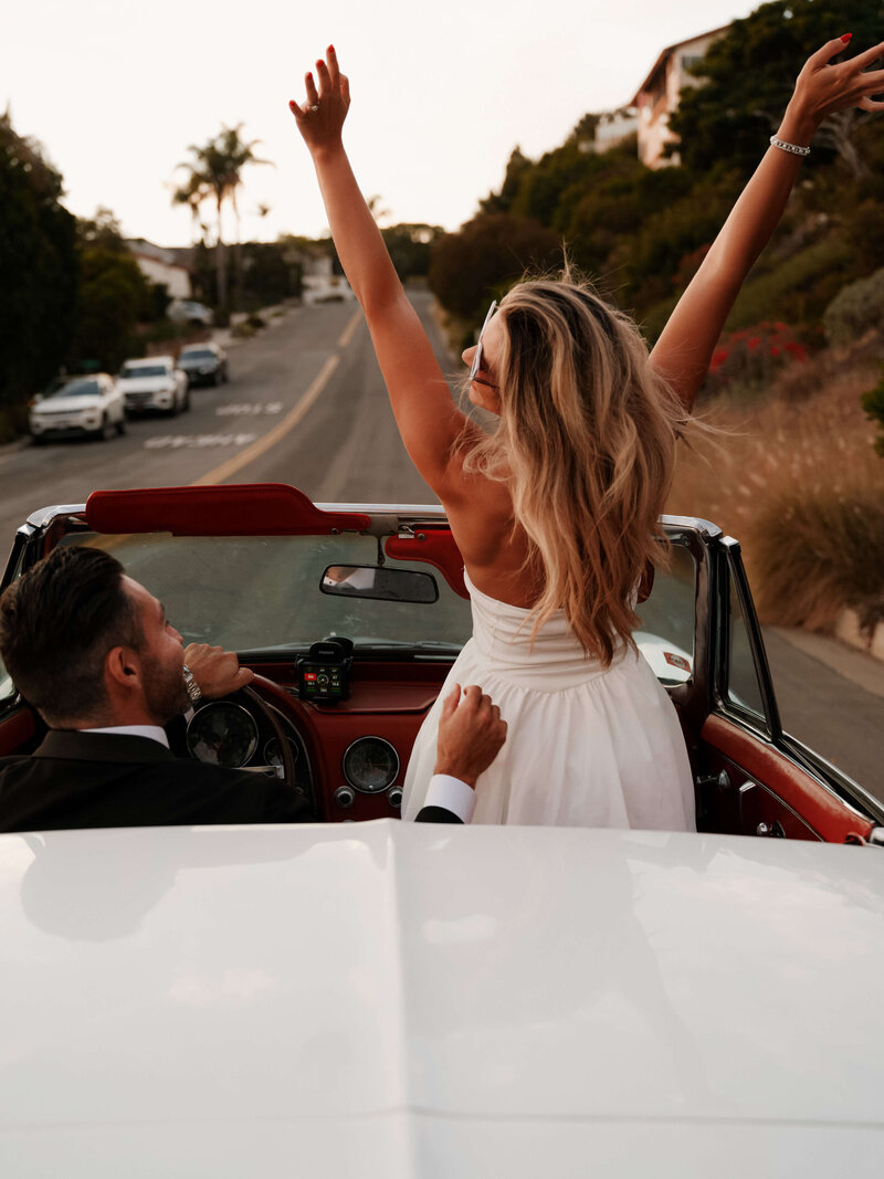 Couple taking engagement pictures in a classic car in Laguna Beach, CA