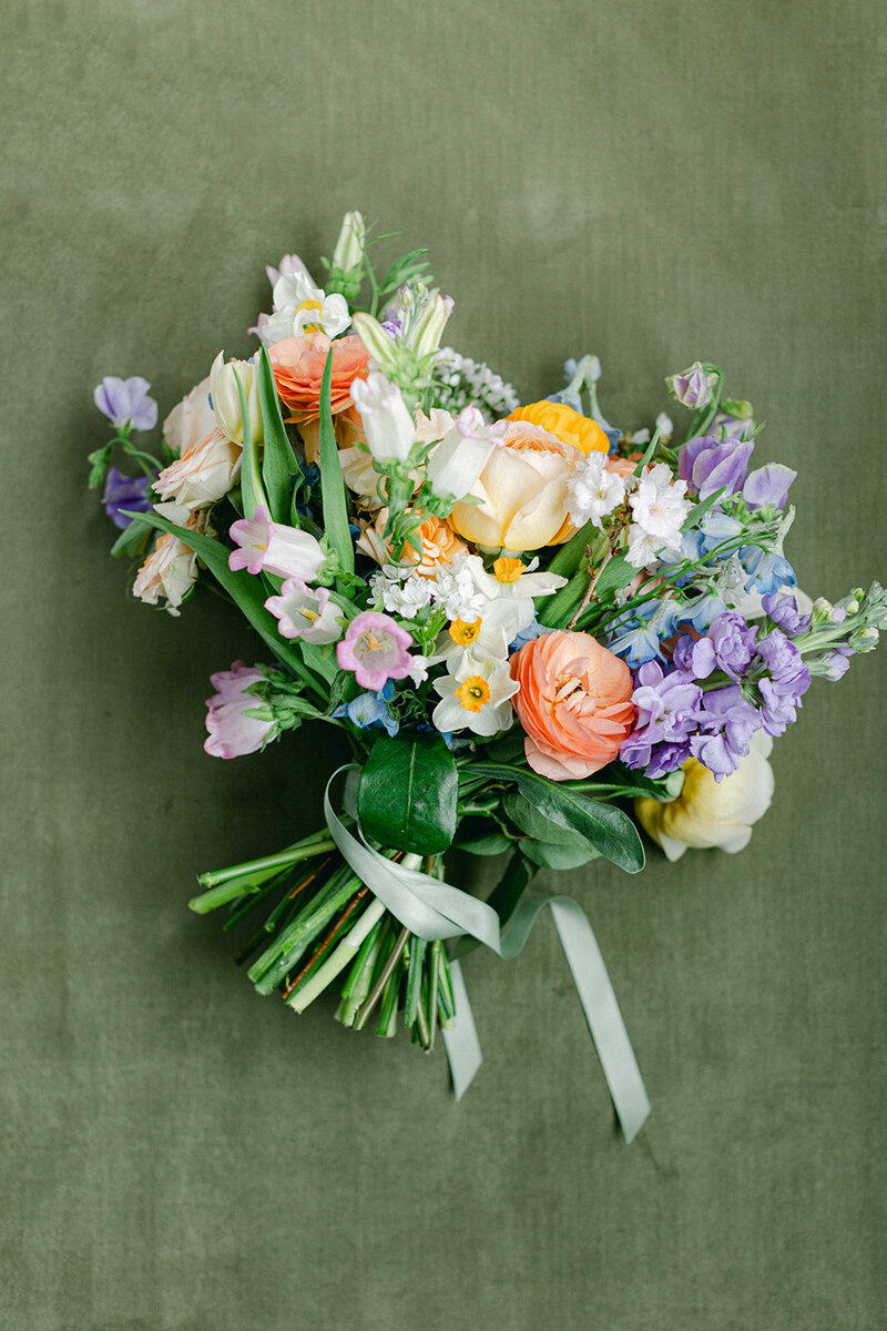 Olive green suede styling mat with wedding details and invitation suite