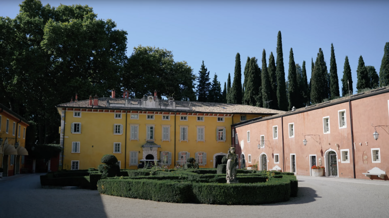 Scenic view of a vibrant Tuscan-style villa with towering cypress trees before a stylish destination wedding in Italy — opening shot from a fine art wedding video