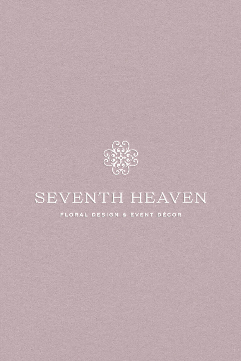 White ornate brand emblem for Seventh Heaven Events on a mauve background