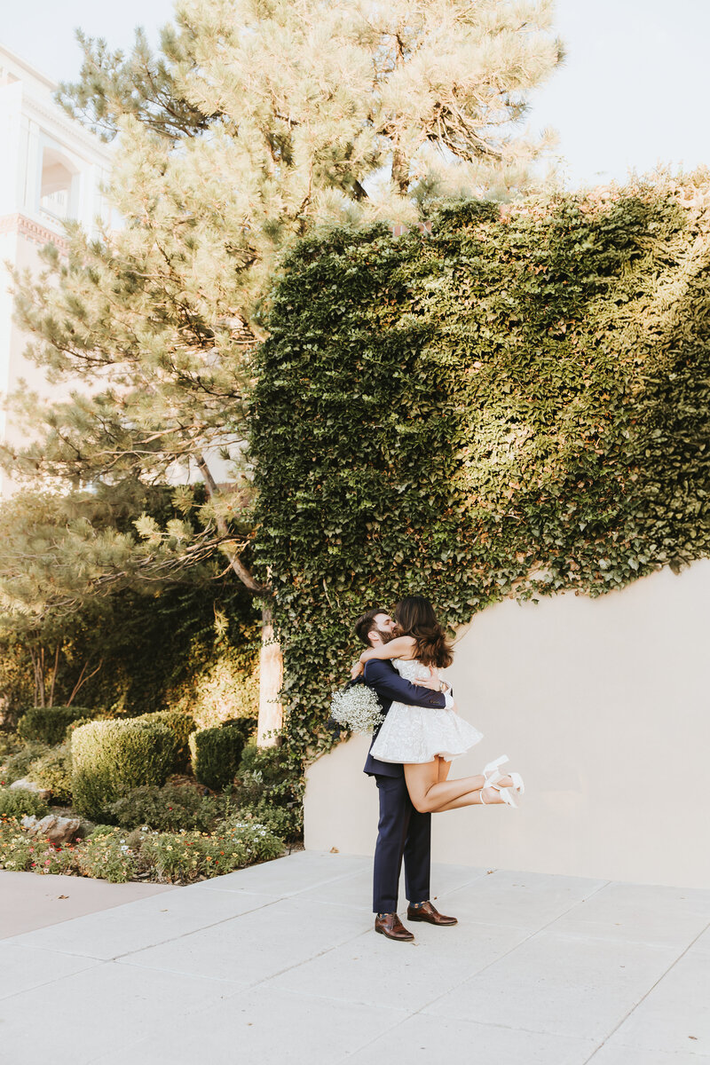 Groom lifting bride during their portrait session at Hotel Albuquerque in Old Town.