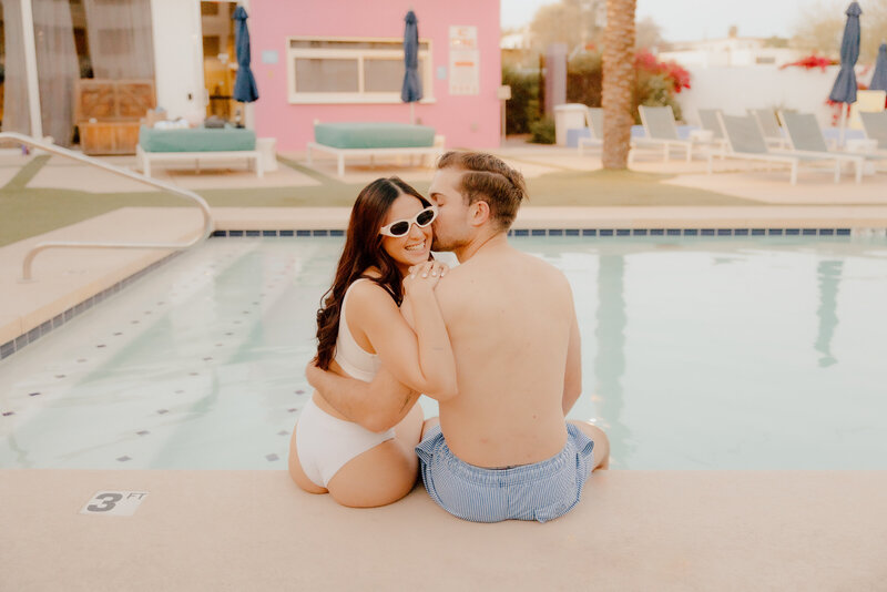 couple sitting next to pool at unique engagement session in st louis