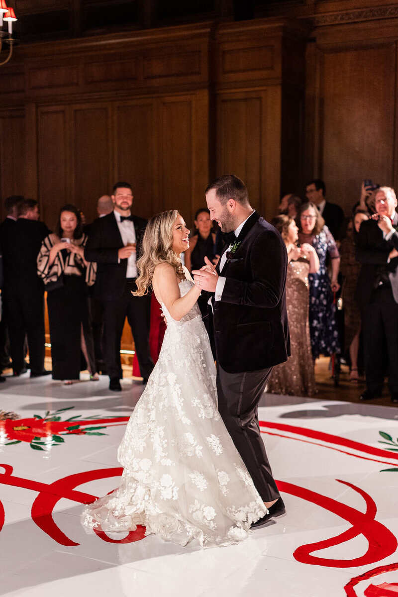 Bride and groom sharing their first dance surrounded by guests