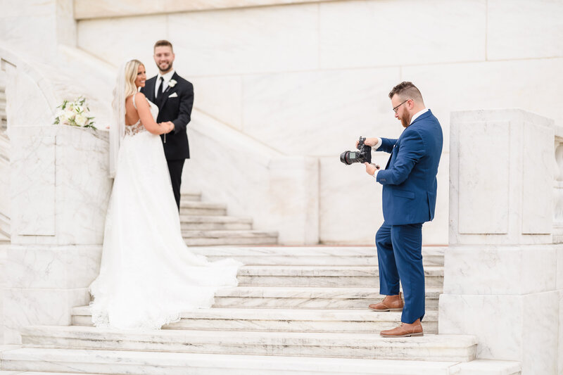 A behind the scenes image of award winning wedding photographer, Zack Bradley as he photographs a couple on the steps of the Detroit Institute of Art