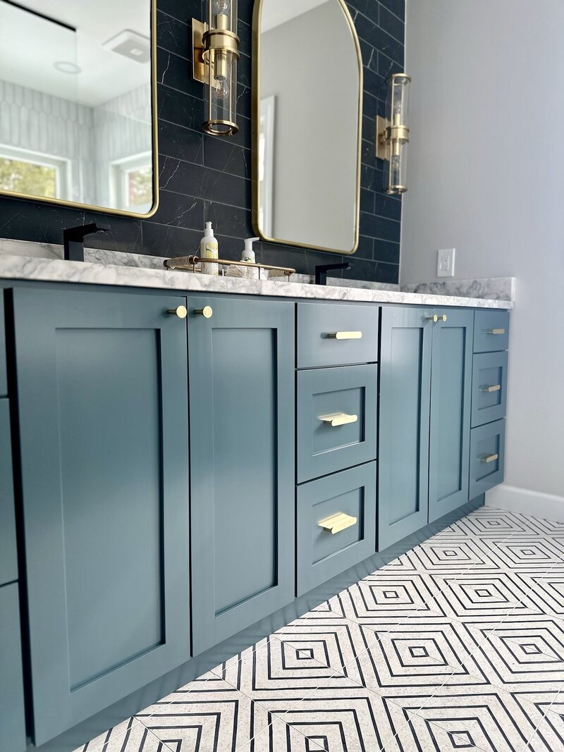 Bathroom with classic white patterned tile and bright blue cabinets and a dark wall