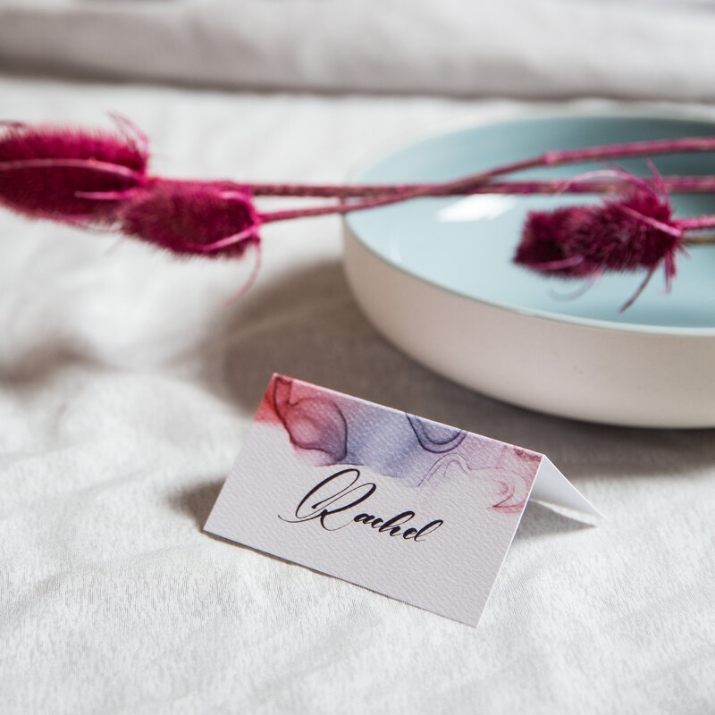 Wedding place card with red blue and purple ink design with script font