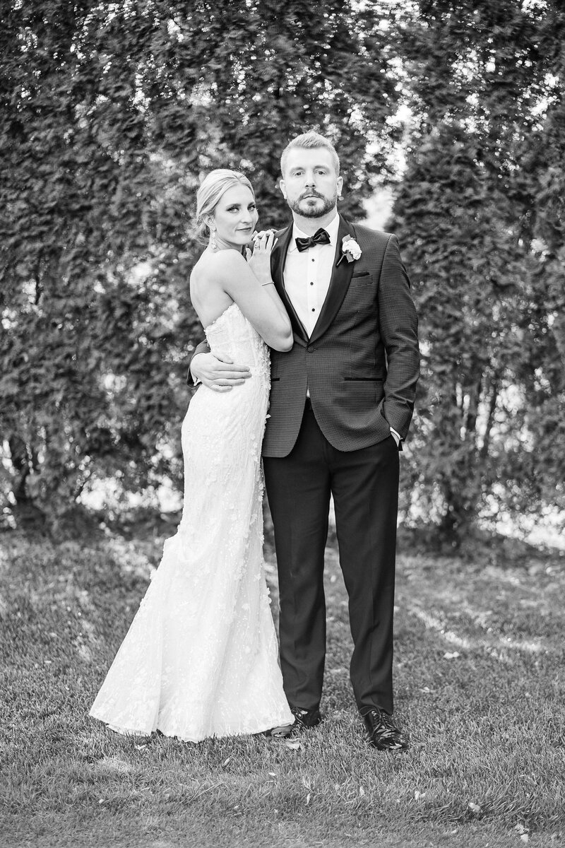 Bride and Groom elegantly hold each other in a  black and white photo