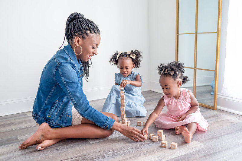 A mom playing blocks with her two daughters during  a family picture session in Huntsville Alabama