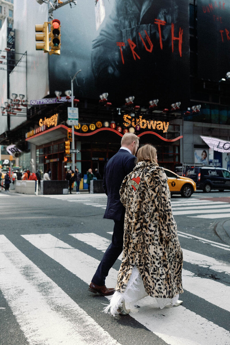NYC elopement times square couple with yellow cab and faux fur coat