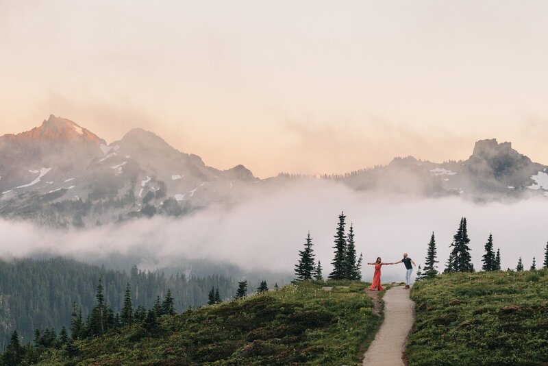 Mixed race couple share a dance in Mt Rainier National park during their engagement session while the clouds roll in