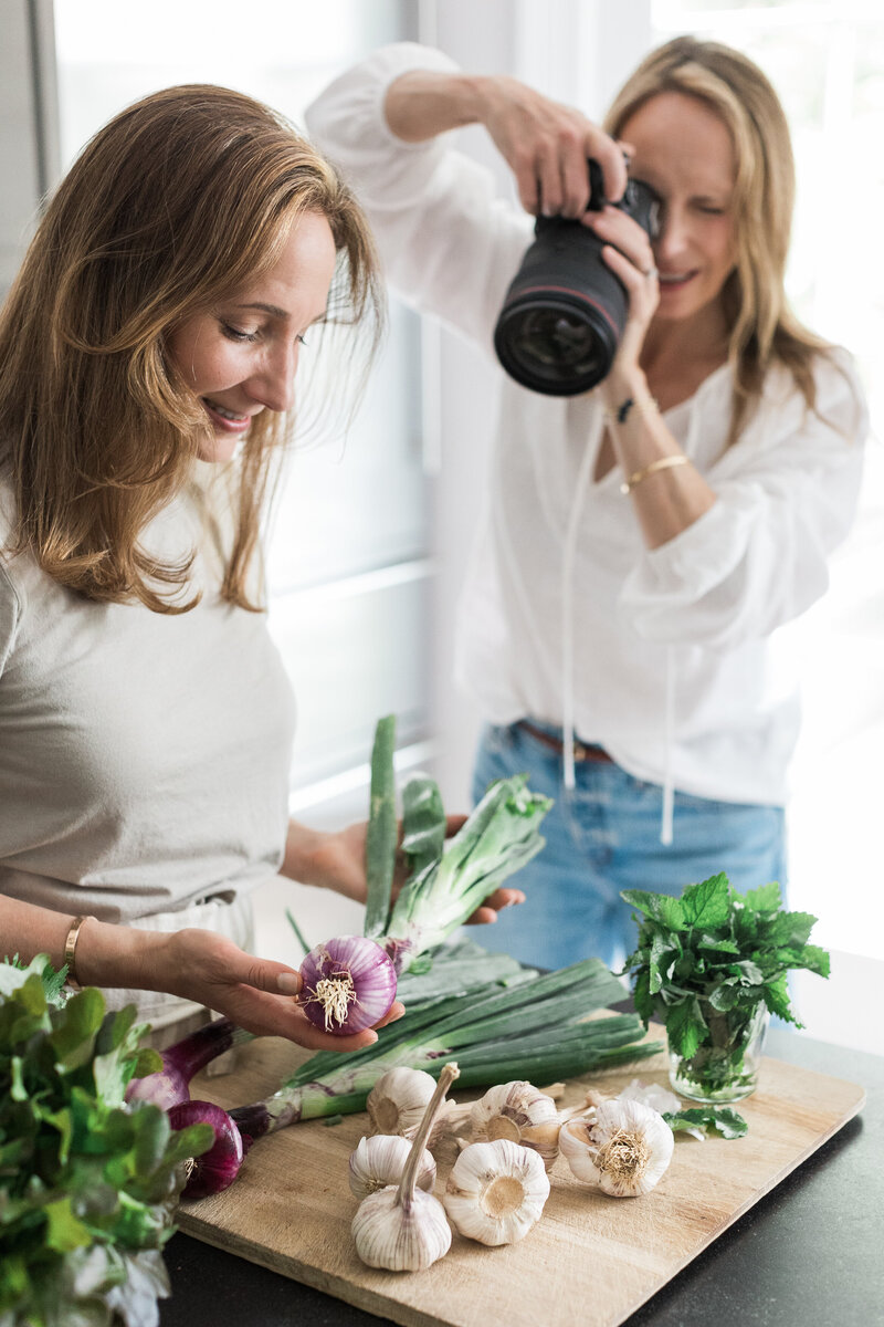 Lisa Scontras, brand photogrpher, taking photos of an influencer working with fresh food and vegetables. 